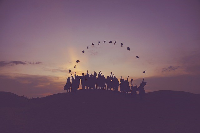 People standing on a hill in dark.