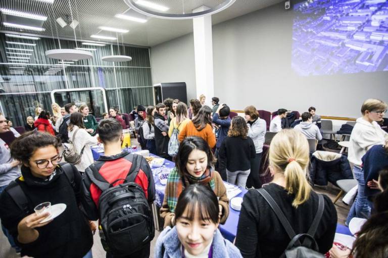 Students gathering around a table in a welcoming event on campus.