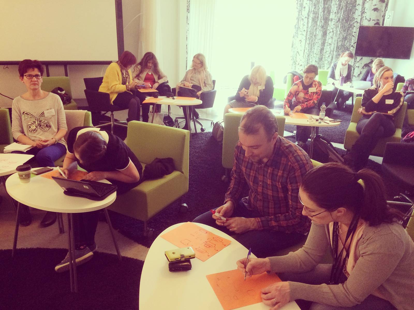 People writing on paper in classroom.