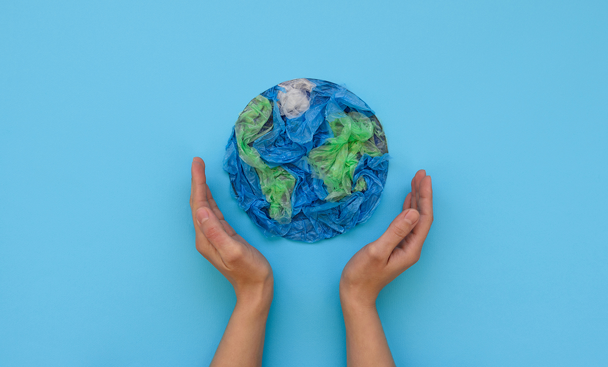 Kädet kohottautuvat kohti muovista puristettua maapalloa.