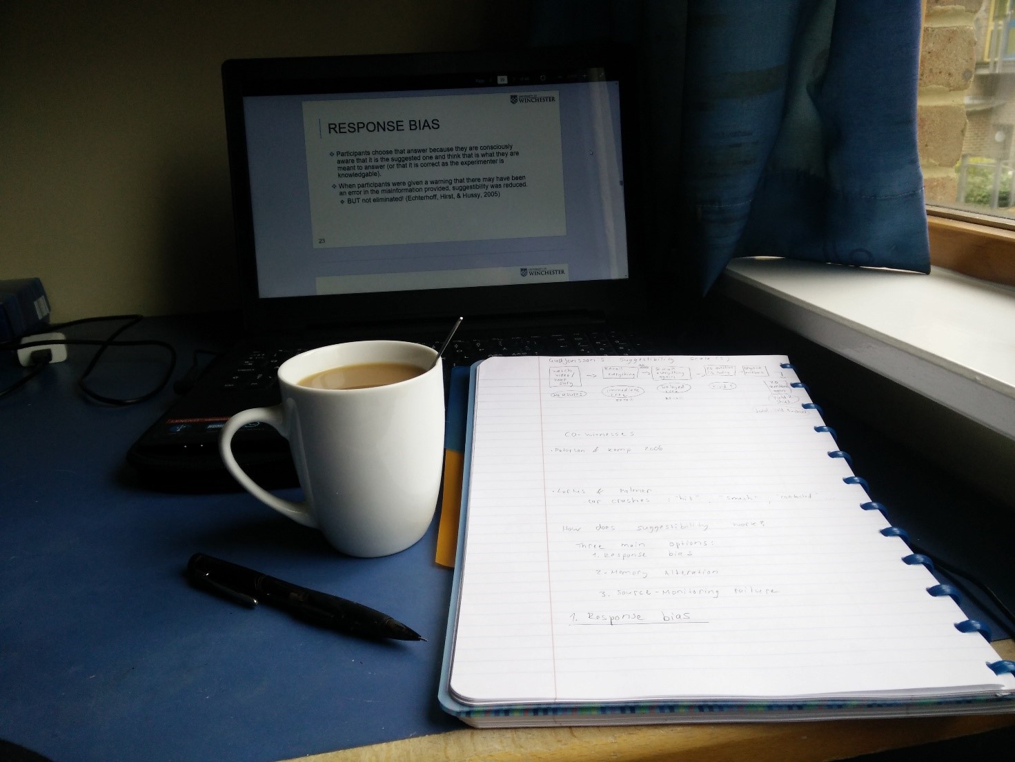 Tietokone, kahvimuki, avonainen vihko