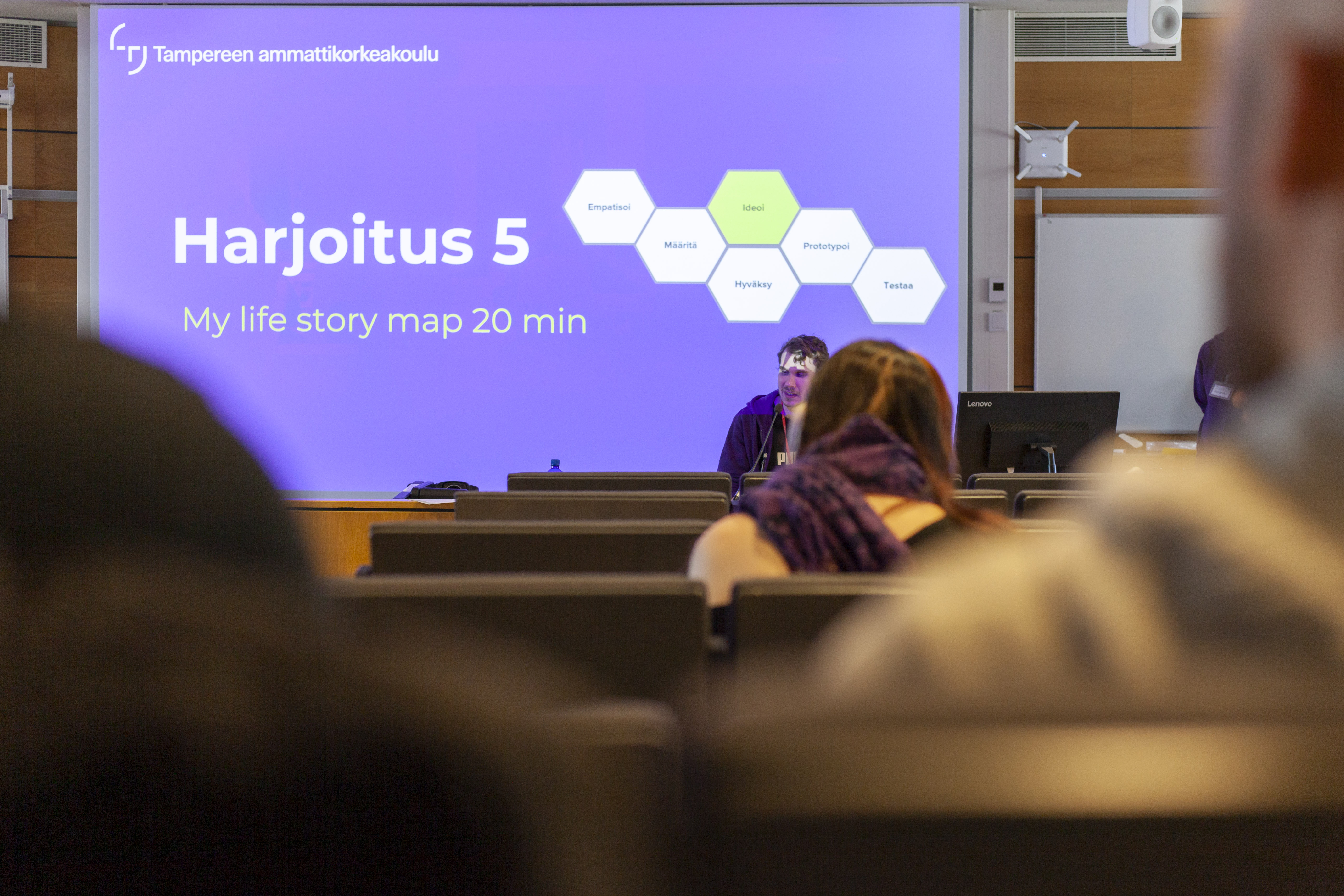 Työpajatyöskentelyä luokkahuoneessa opettaja mukanaa