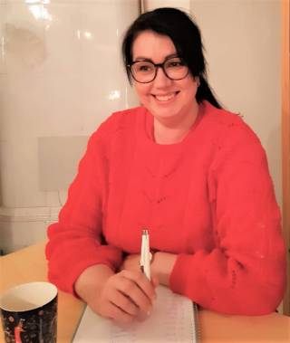 Terhi hymyilee pöydän äärellä.