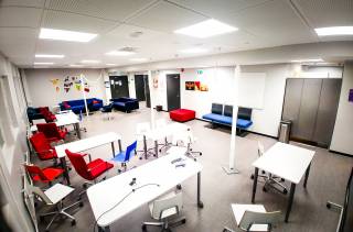 Huone, jossa muutama sohva, pöytiä ja tuoleja