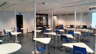 Luokka, jossa paljon pöytiä (pulpetteja) ja tuoleja