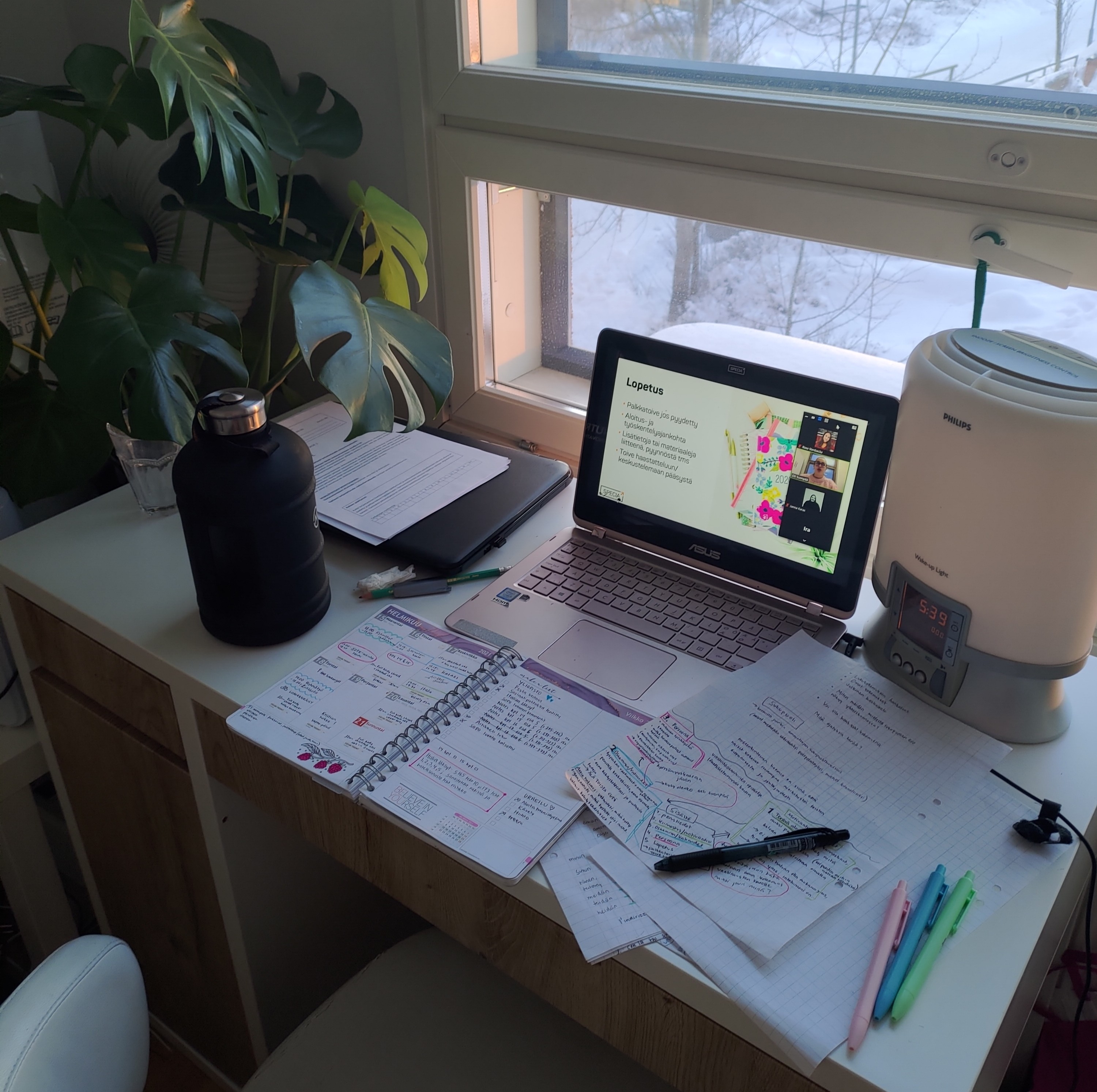 Työpöytä, muistiinpanoja ja avonainen läppäri.