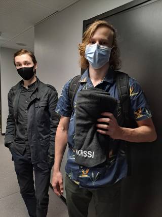 Kuva, jossa kaksi poikaa on hakemassa vilttiä ja toinen näyttää vilttiä.