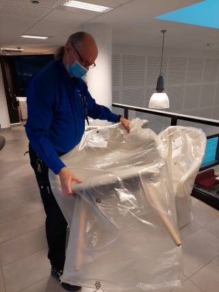 Kuva, jossa vahtimestari nostaa tuolia.