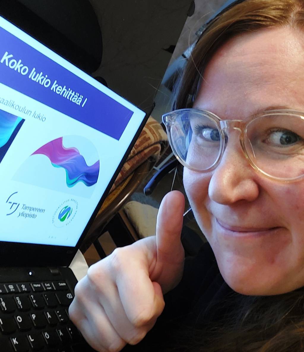 Kuva, jossa etäkonferenssissa tietokoneen ruudulla näkyy hankkeen esitys, jota naishenkilö on esittämässä näyttäen peukkua.