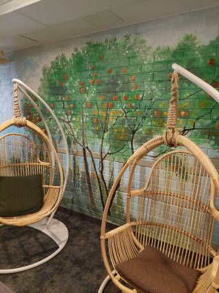 Kuva, jossa riipputuolit ja seinämaalaus