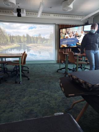 Kuvassa virtuaalitila, jossa opettaja esittelee ja kertoo tilasta