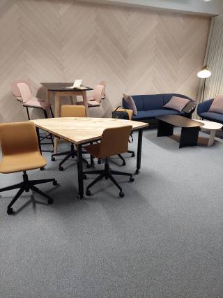Kuvassa immersiivinen tila kalusteineen: mm. pöytiä ja tuoleja