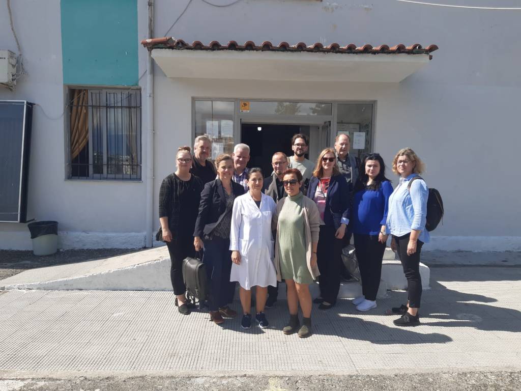 People pose for picture outside of building.