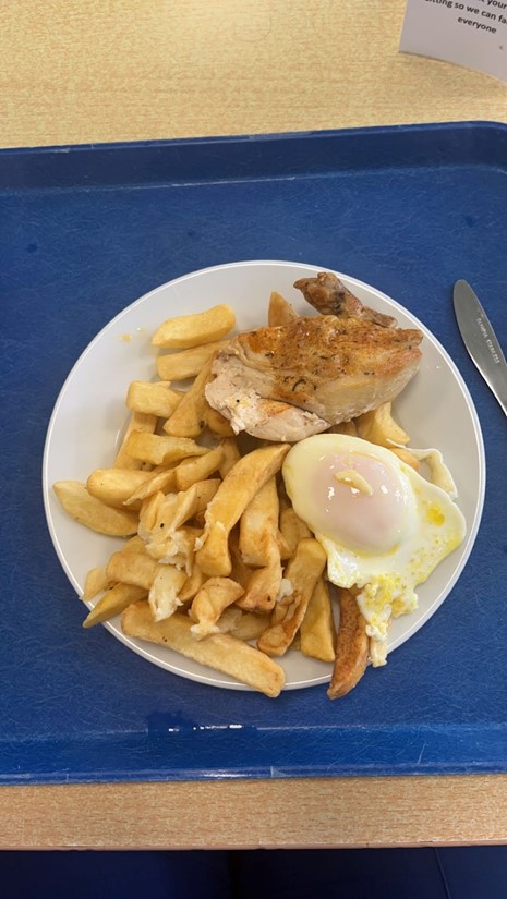 paistettuja perunoita, kanaa ja uppopaistettu muna