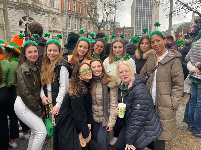 Opiskelijoita yhteiskuvassa, päässä vihreät apilapannat