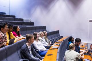 Opiskelijat istuvat luentosalissa.