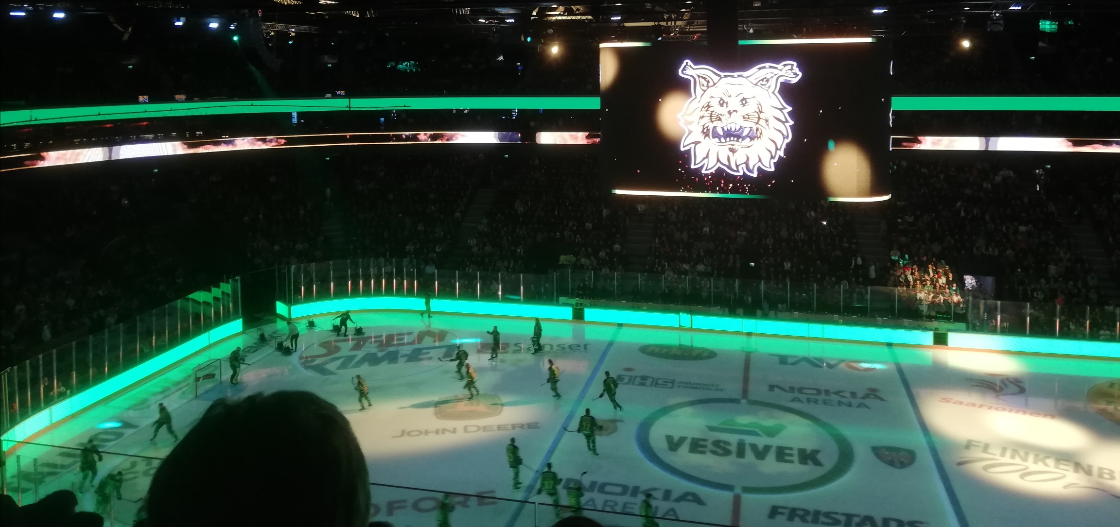 Ilveksen pelaajat luistelevat kaukaloon, jonka laidat ovat vihreät 