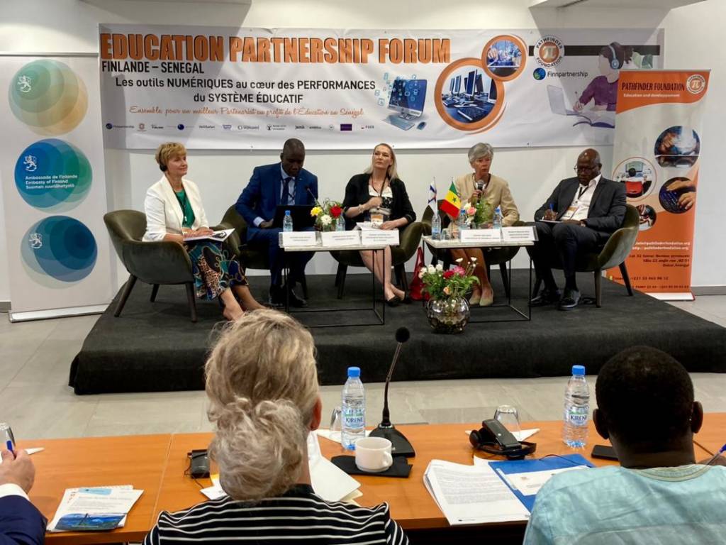 Five people sitting on a stage and discussing.