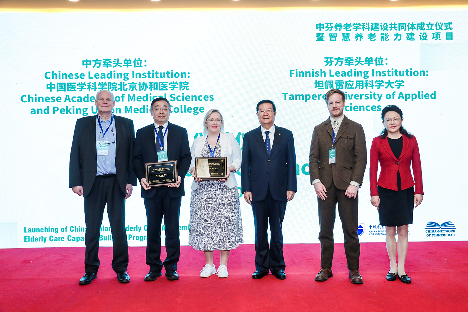 Six people standing together on a stage.