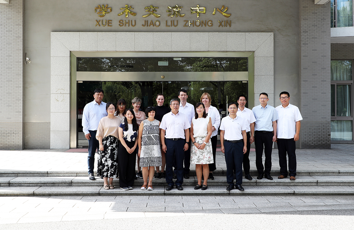 Fifteen people standing in front of a building.