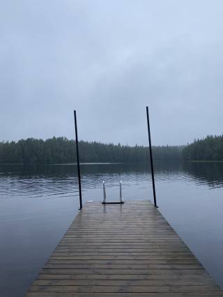 Sumuinen syysmaisema laiturinnokassa.