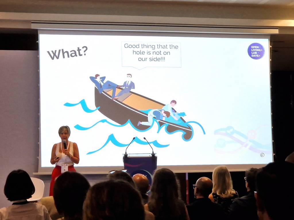 A woman standing on a stage and talking to a microphone.
