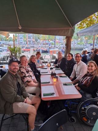 Ryhmä ihmisiä istuu ravintolan pöydässä.