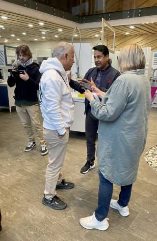 Kolme ihmistä keskustelee seisten.