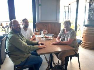 Three people sitting around a table.