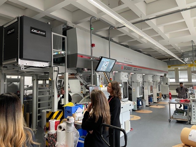 People in a univeristy campus looking at screen.