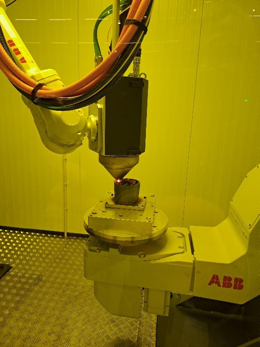 Meltion metallilankatulostinjärjestelmä Meltio Engine Blue DED Integration Kit (WAAM, laser) toiminnassa ABB-käsivarsirobottisolussa.