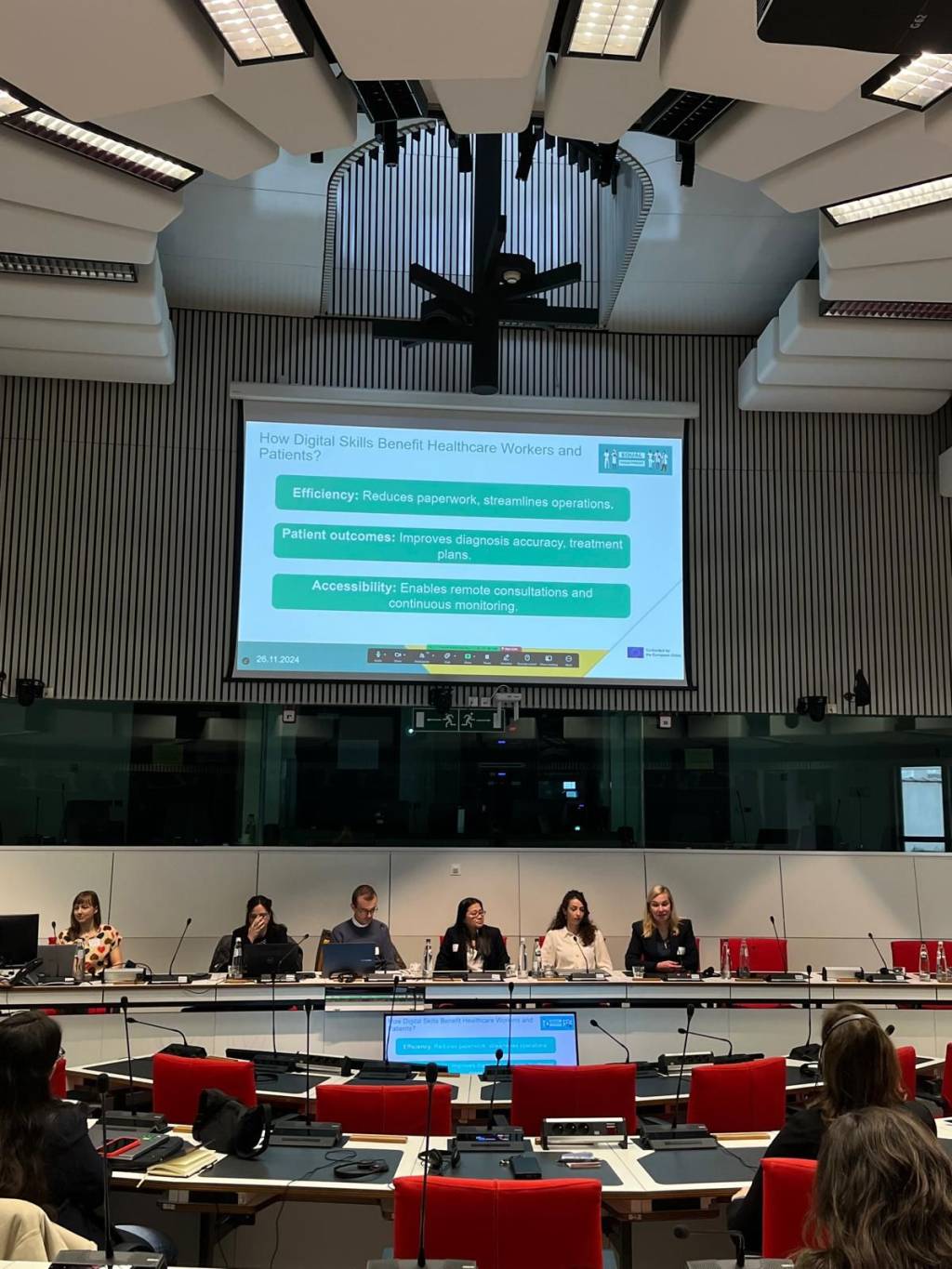 Ihmisiä istumassa lavalla pitämässä esitystä.