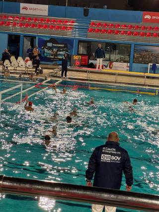 Ihmisiä pelaa vesipoloa uimahallin altaassa