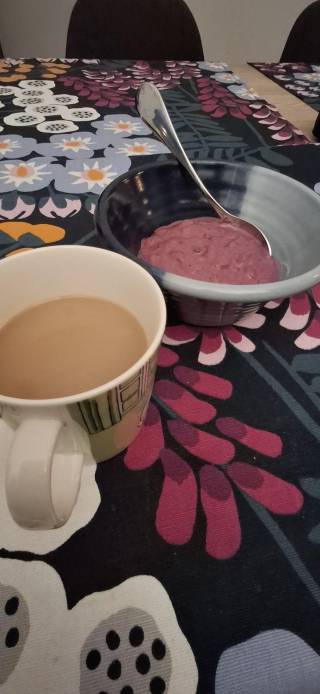 Kuva aamiaispöydästä, etualalla kahvikuppi.