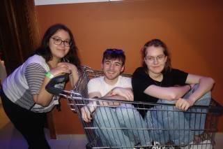 Kolme henkilöä ostoskärryssä