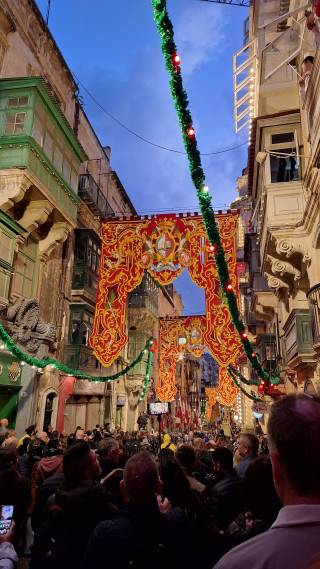 Ihmisiä kadulla illalla juhlimassa