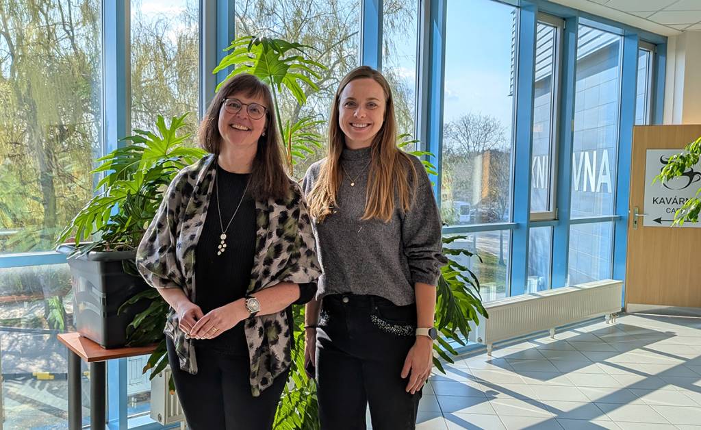 Kaksi naista seisomassa valoisalla käytävällä.