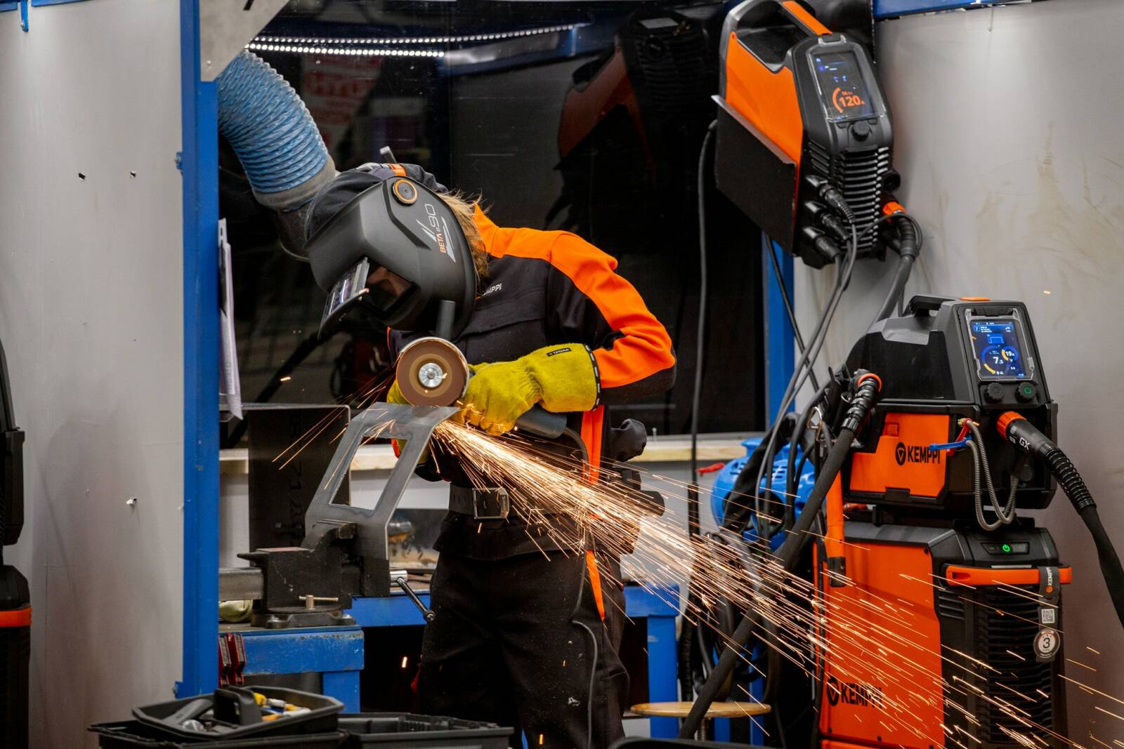 Hitsausta Taitaja2022-kilpailussa. Kuvassa näkyy yksi henkilö hitsaamassa sekä kipinöitä.
