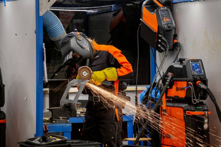 Hitsausta Taitaja2022-kilpailussa. Kuvassa näkyy yksi henkilö hitsaamassa sekä kipinöitä.