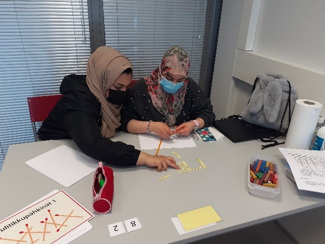 Kaksi opiskelijaa istuu vierekkäin ja tekee matematiikan tehtäviä.