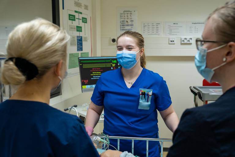 Kolme sairaanhoitajaopiskelijaa juttelee keskenään.