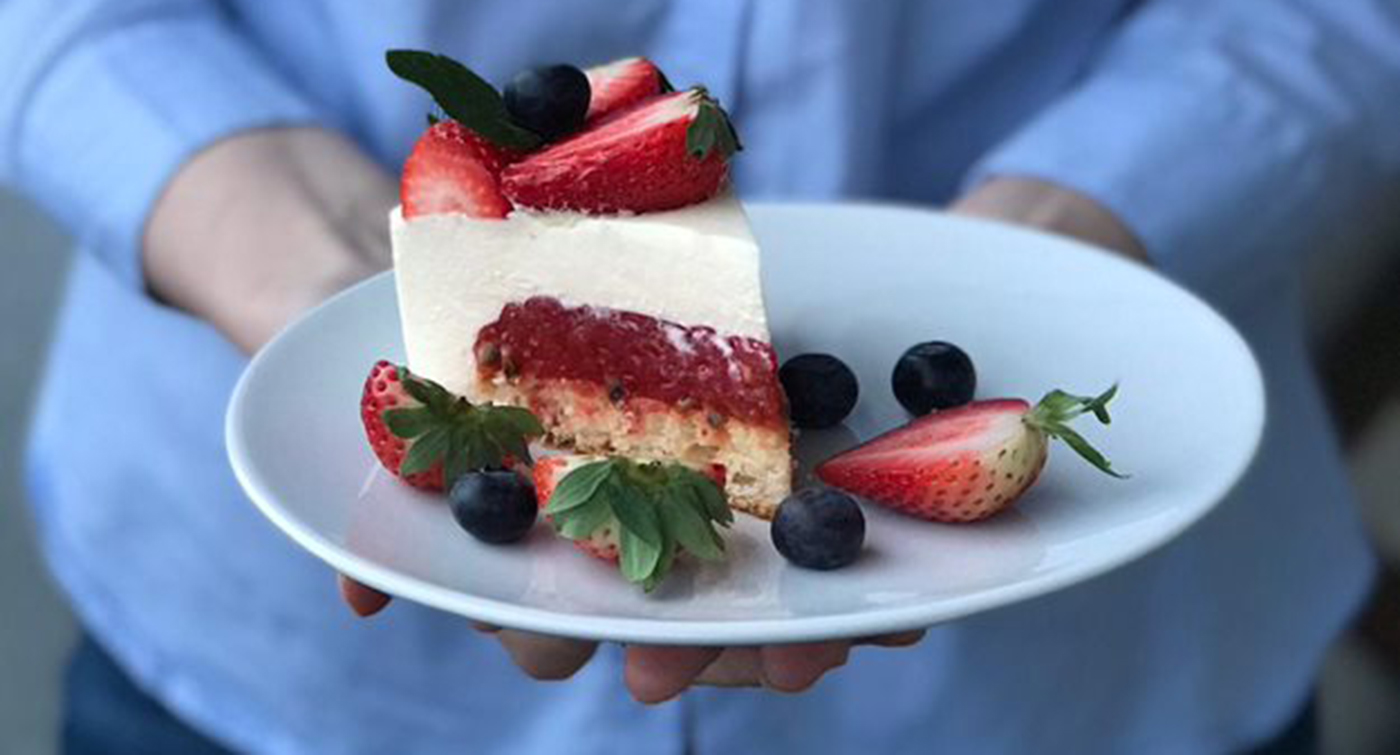 Marjoilla koristeltu kakkupala lautasella.