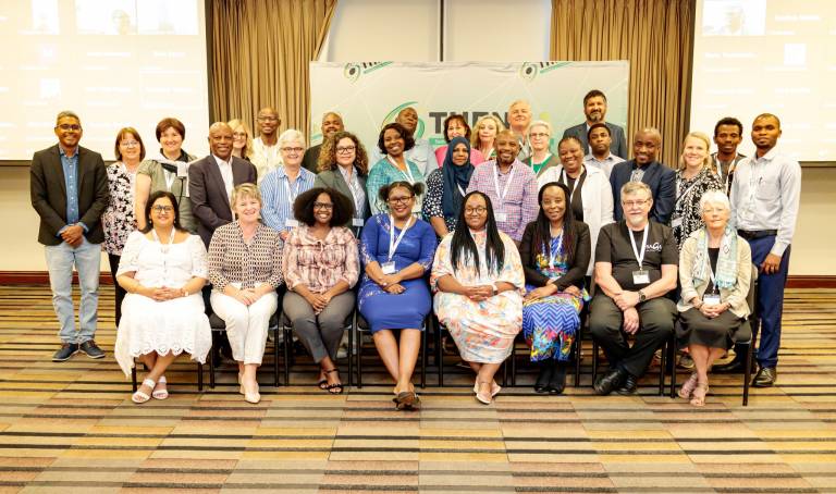 Ihmisiä istumassa ja seisomassa ryhmämuodostelmassa.