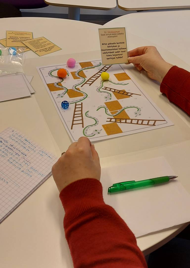 Kädet ja pelilauta.