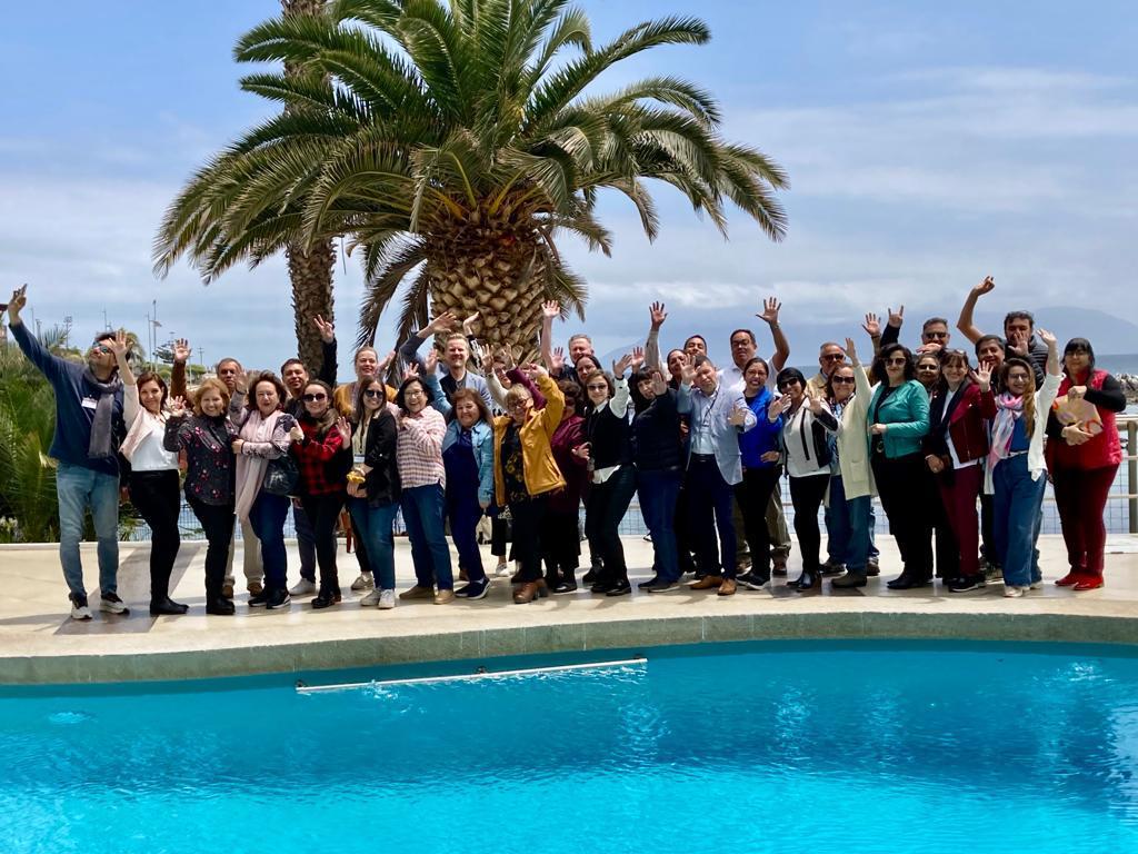 Group picture of people standing behind a pool.