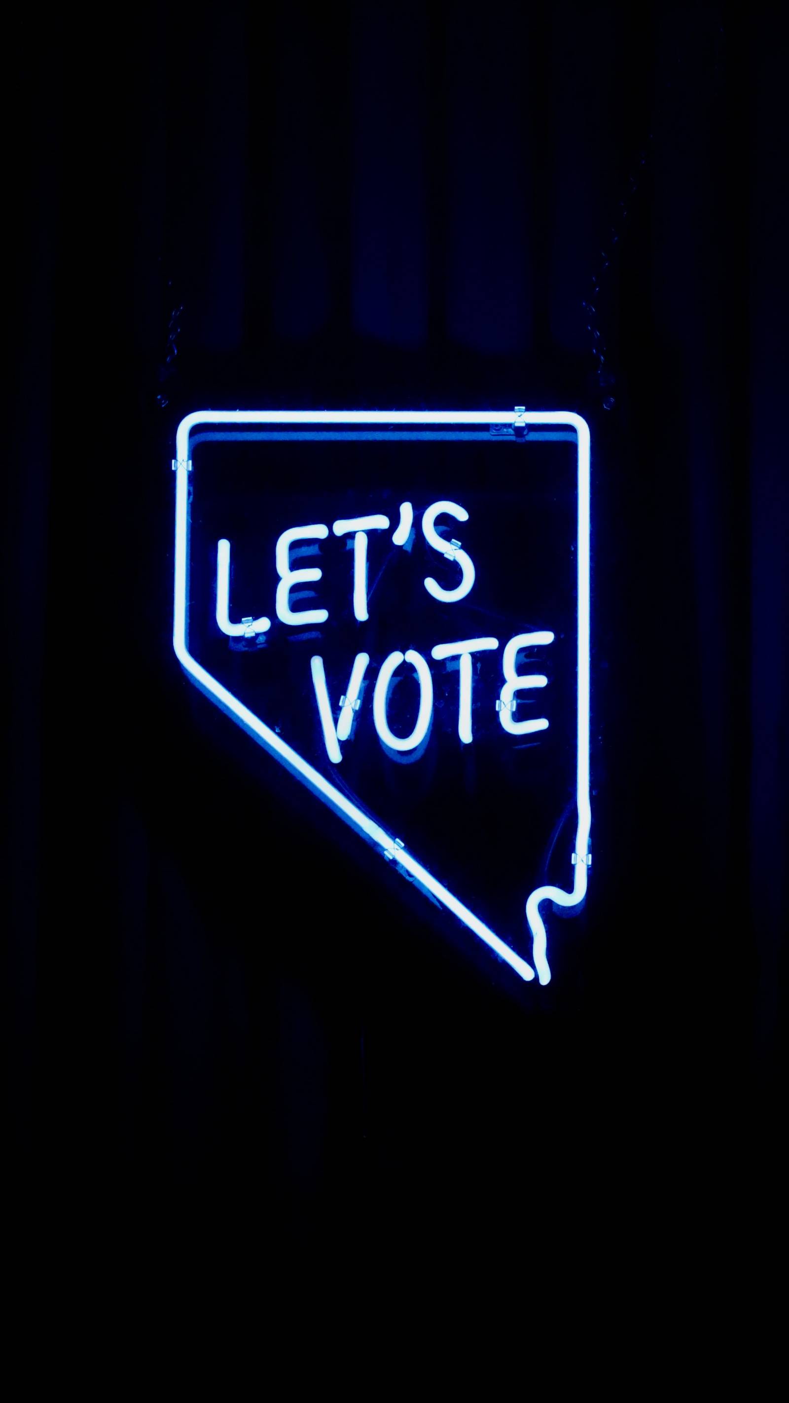 Kuva, jossa musta tausta ja valoputkista luotu puhekupla, jossa lukee Let`s vote eli suomeksi äänestetään