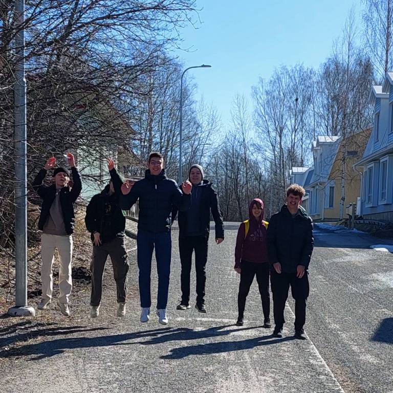 Kuva, jossa opiskelijoita hyppää ilmaan kadulla.