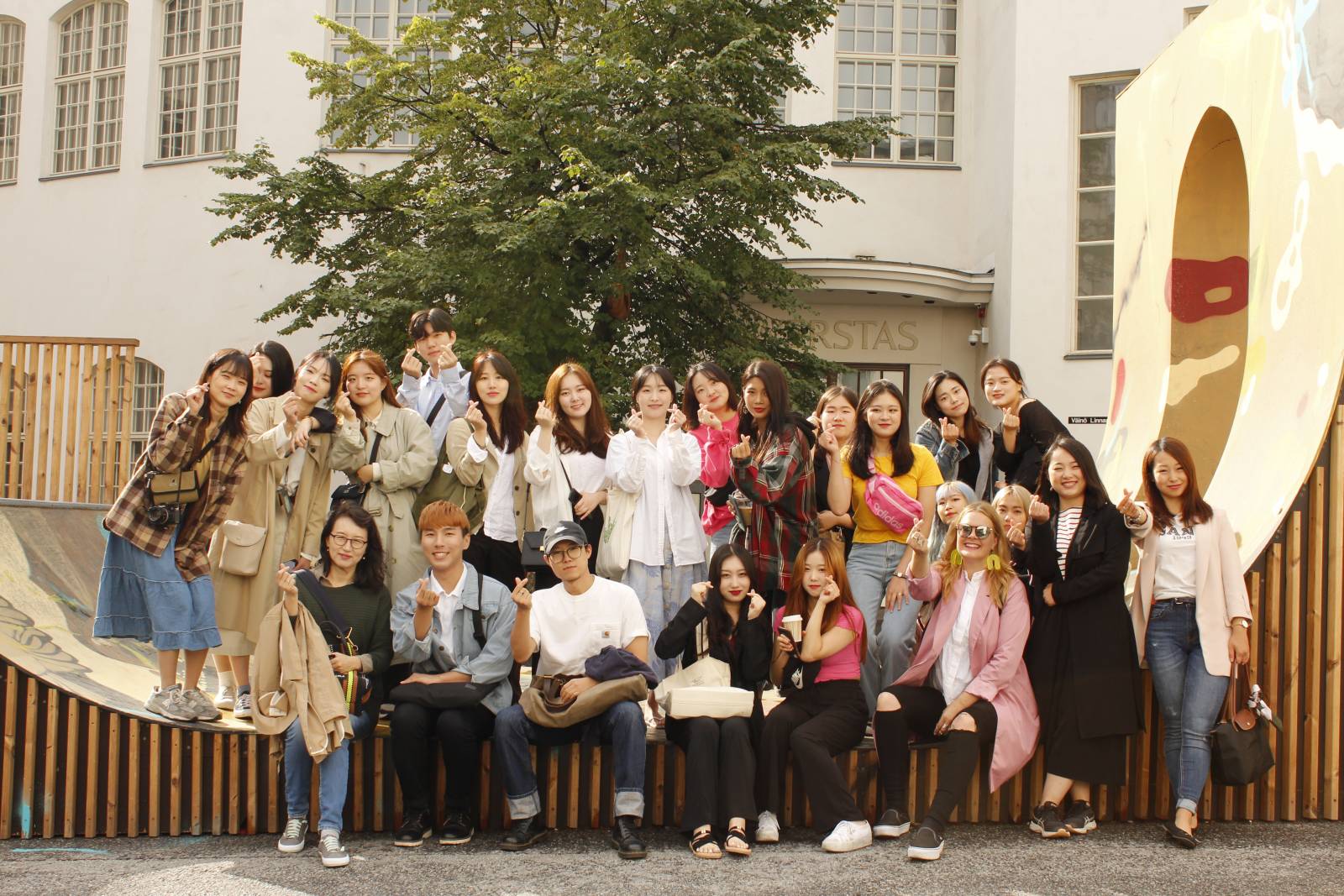 Group picture of students taken outside under a tree.