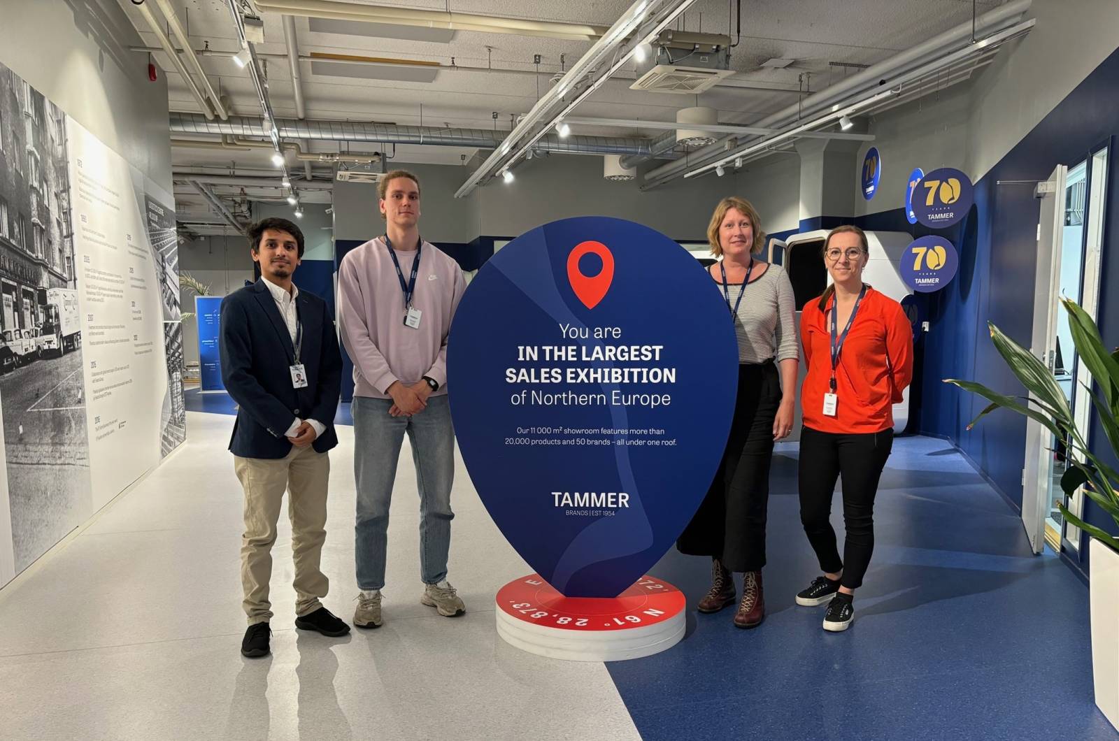 Four people standing next to Tammer Brands stand.