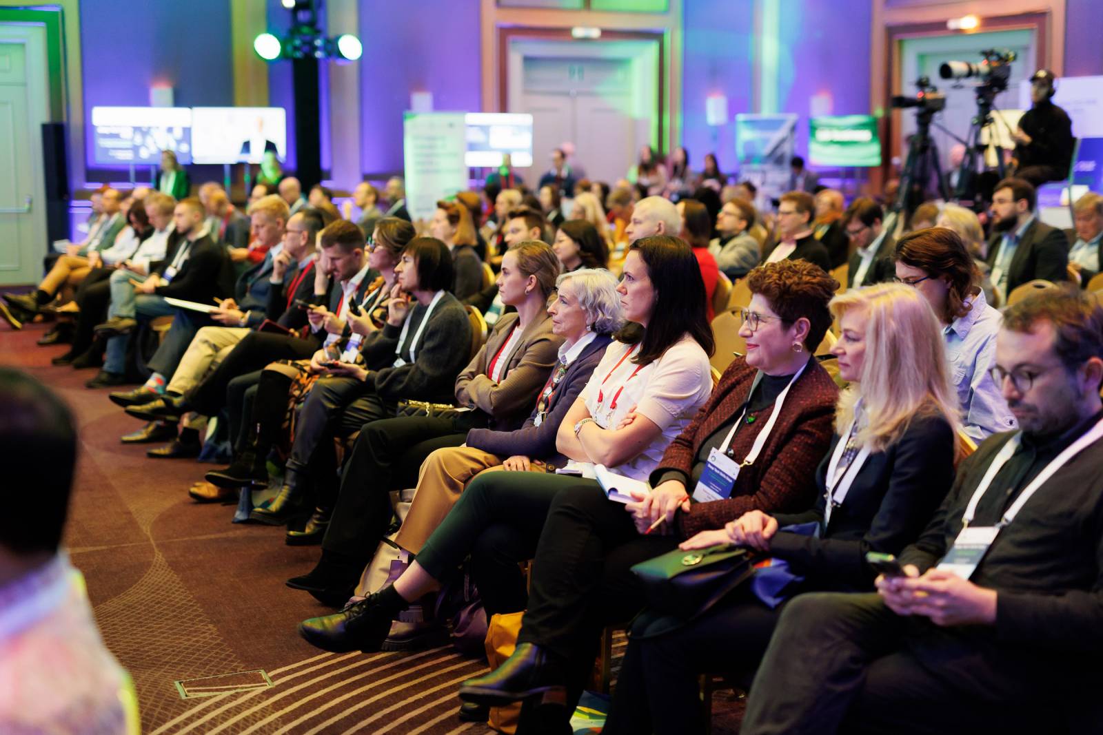 Kuva 1: Yleisöä istumassa ja katsomassa kohti lavaa.